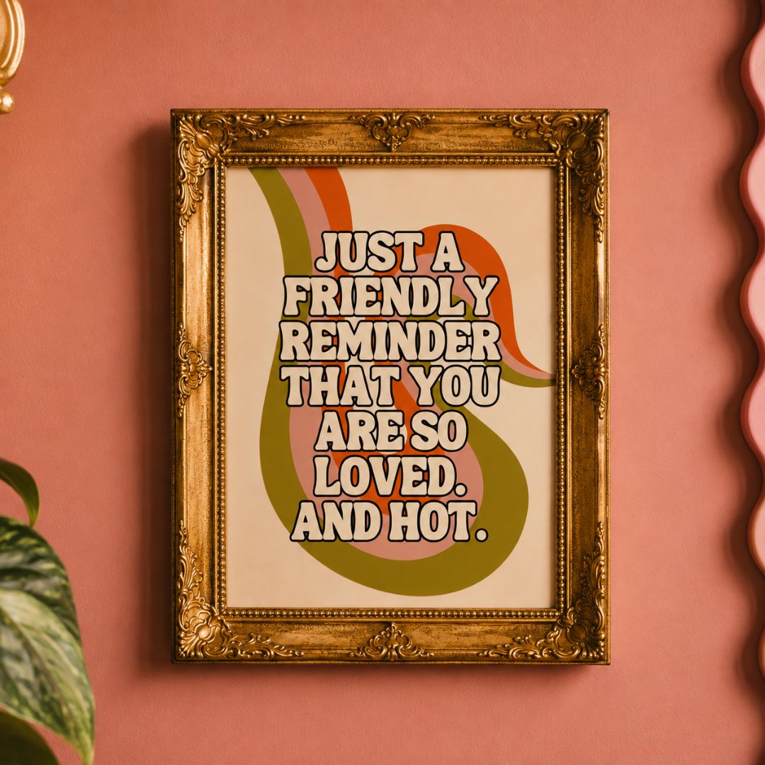 A framed retro-style art print with the text 'JUST A FRIENDLY REMINDER THAT YOU ARE SO LOVED. AND HOT.