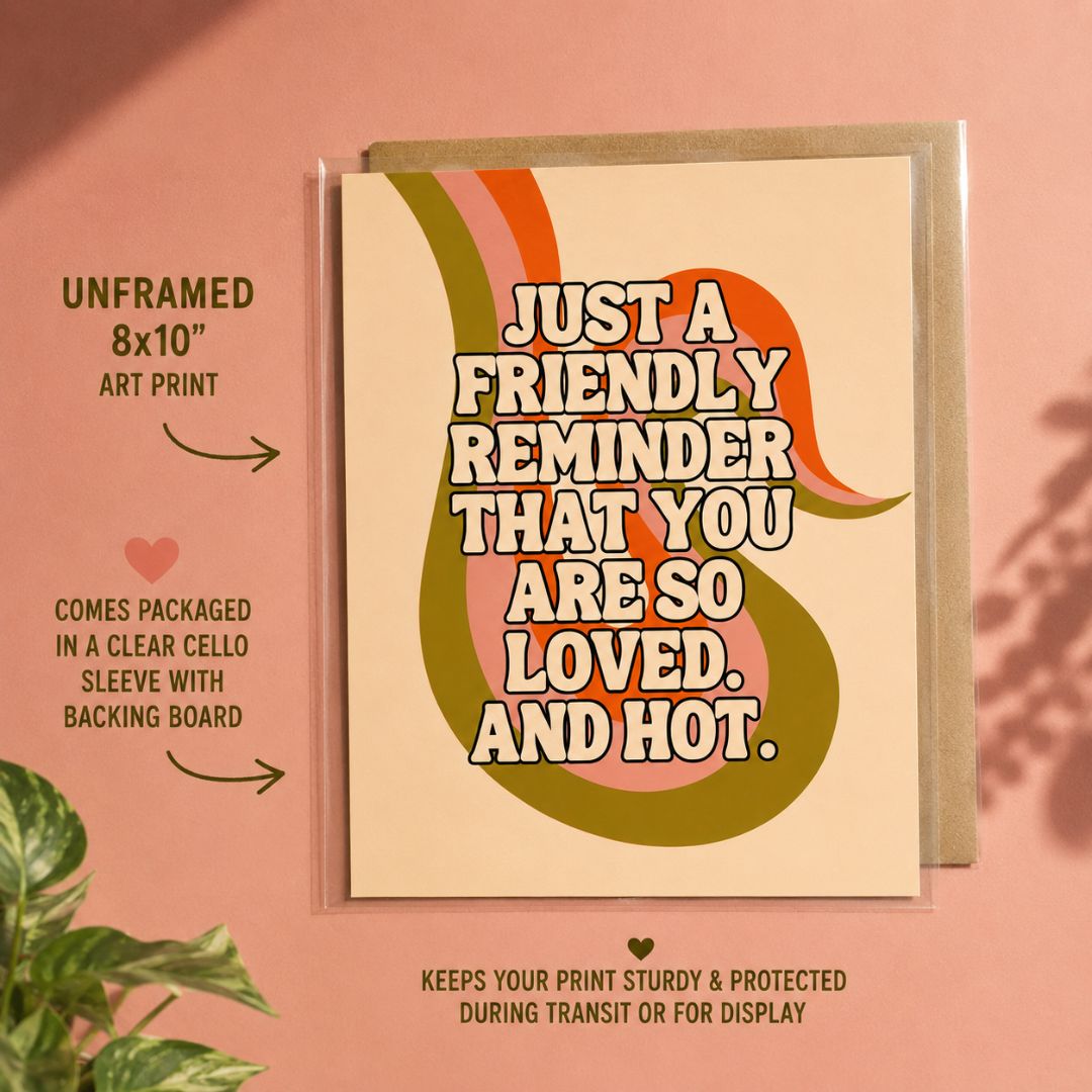 A retro-style art print card reading “JUST A FRIENDLY REMINDER THAT YOU ARE SO LOVED, AND HOT.” shown with a clear sleeve and kraft envelope on a pink background, with text callouts about the unframed 8x10 art print and packaging.