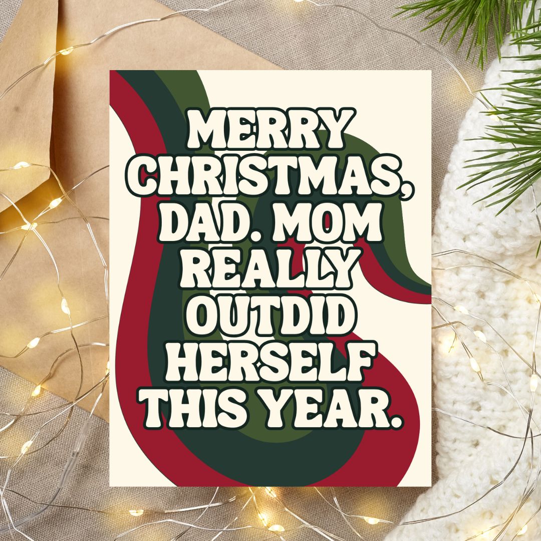A Christmas-themed greeting card with the text 'MERRY CHRISTMAS, DAD. MOM REALLY OUTDID HERSELF THIS YEAR.