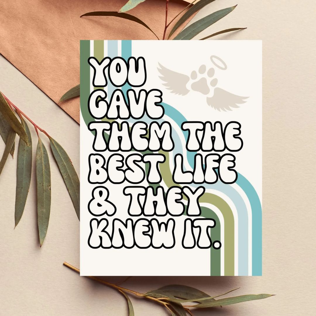 A square memorial-style greeting card with the phrase “YOU GAVE THEM THE BEST LIFE & THEY KNEW IT.” in large outlined letters, plus a small angel paw print and rainbow graphic.